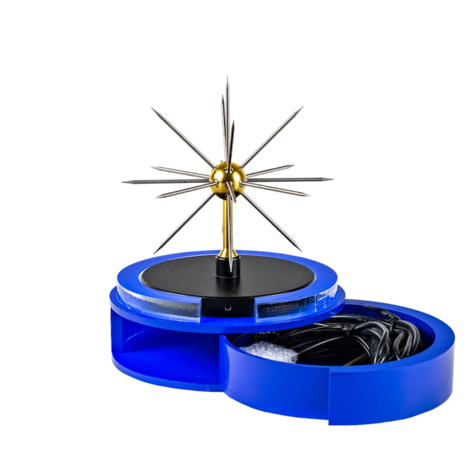 Blå, rund boks med en sort skive og en gylden kule med tynne metallpigger som stikker ut, på hvit bakgrunn