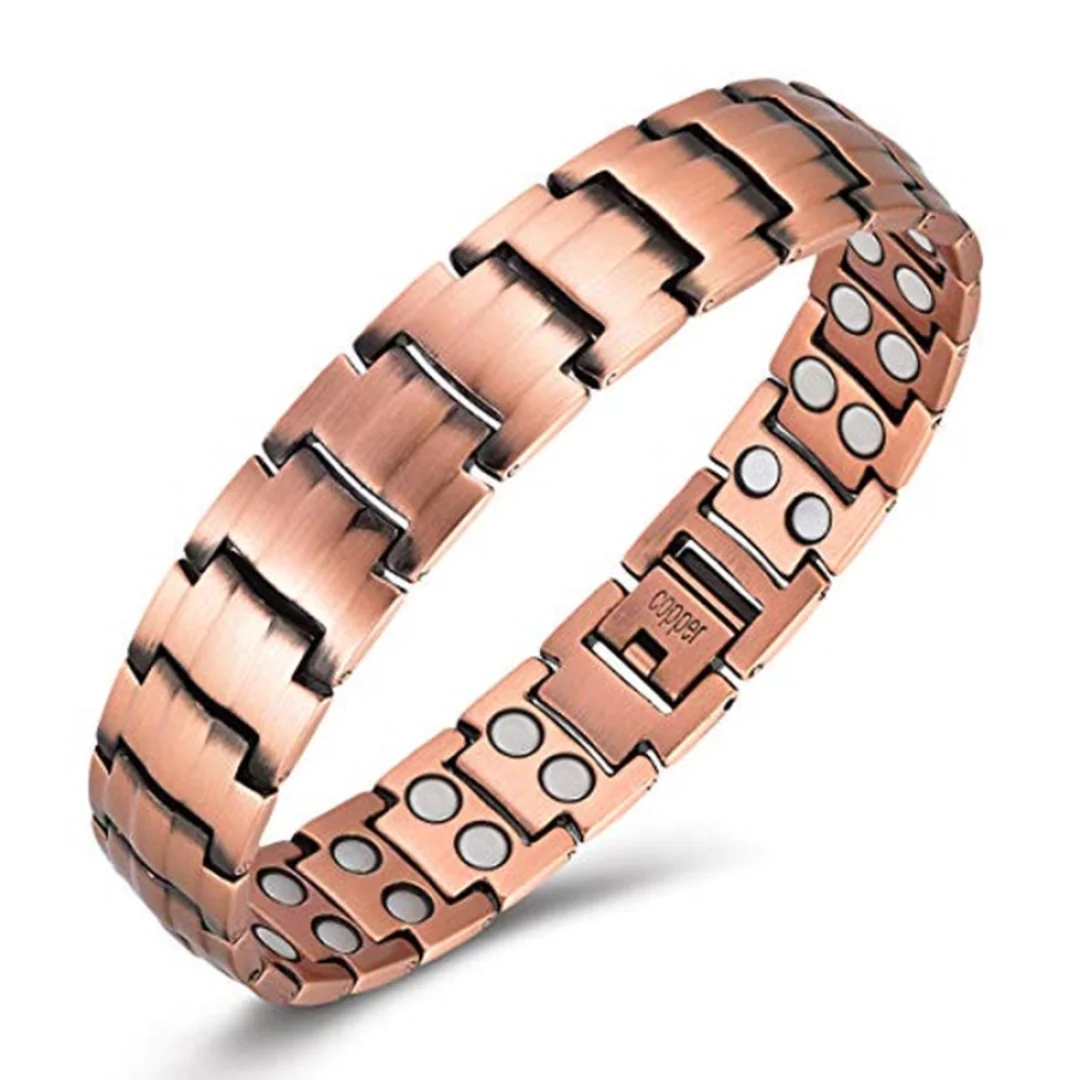 Armbånd i kobber med innfelte magneter, sett skrått ovenfra på hvit bakgrunn