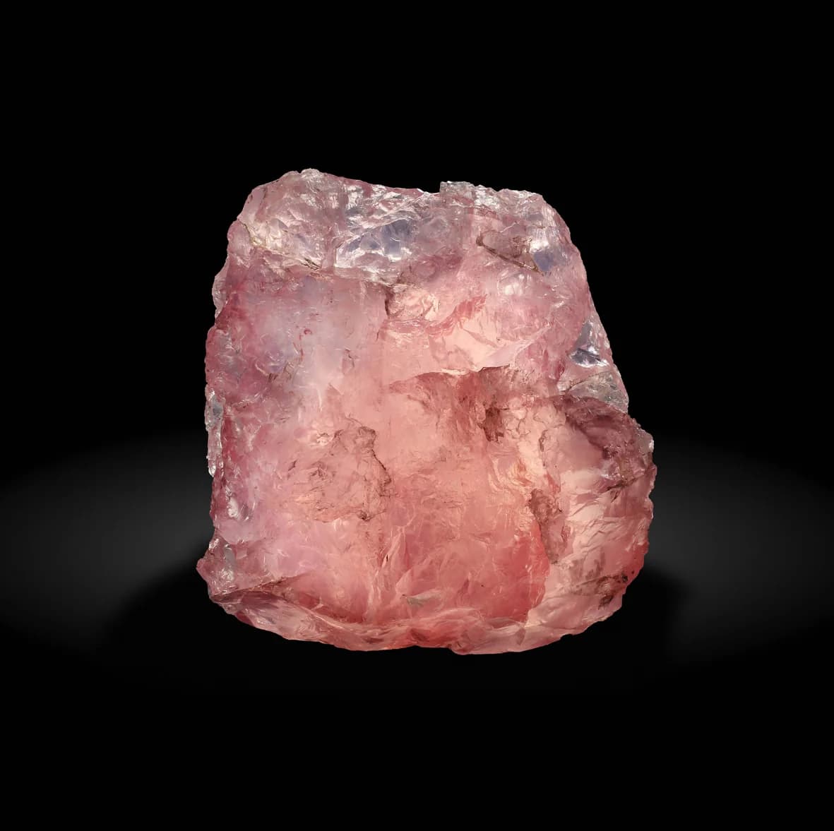 Rå, rosa rosekvarts-stein på svart bakgrunn
