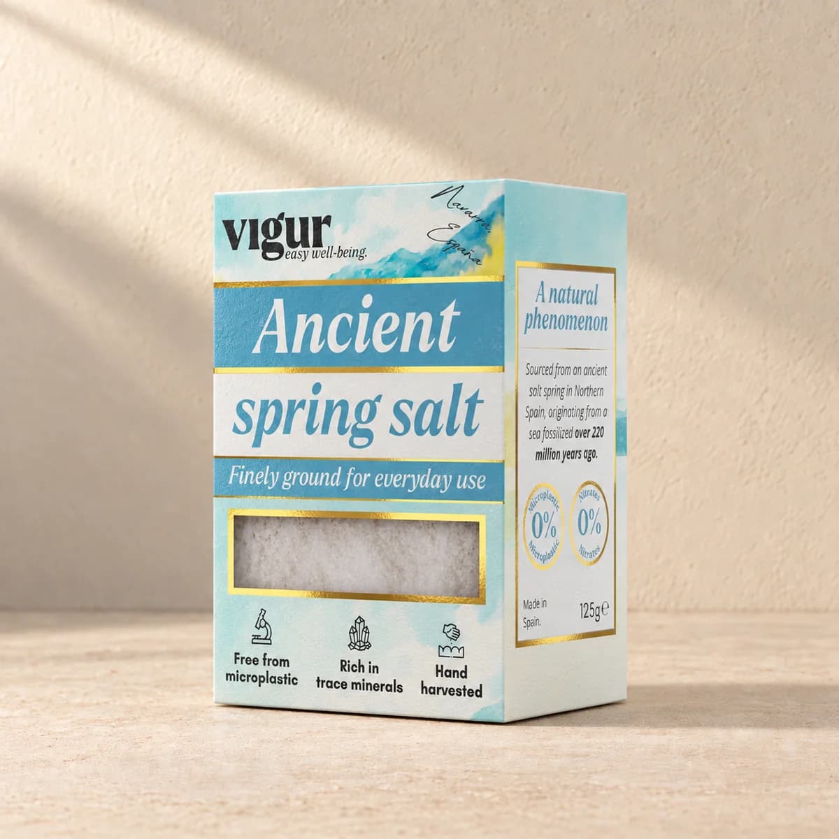 Lyseblå eske med teksten «Ancient spring salt» og Vigur-logo, med fint hvitt salt synlig i et vindu