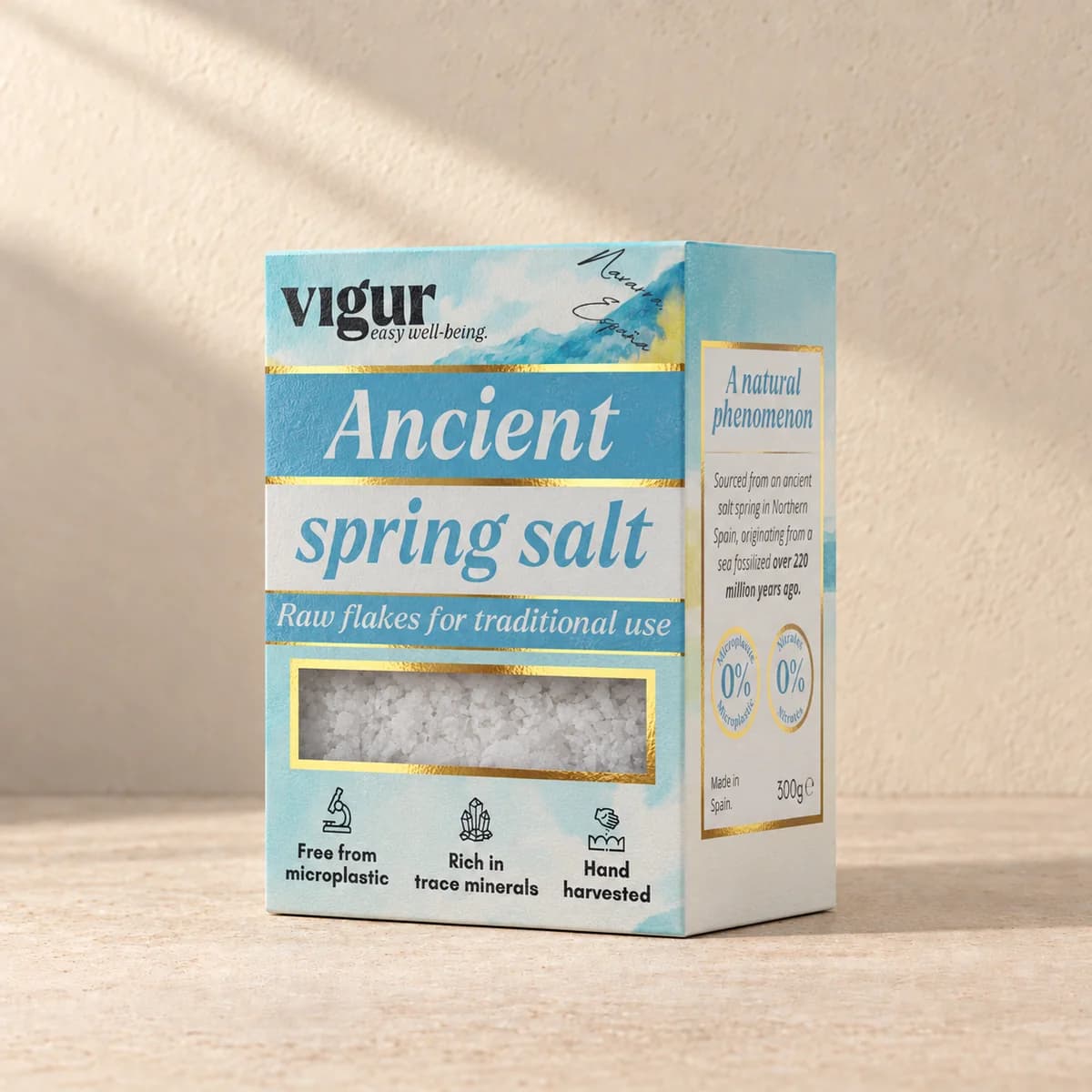 Lyseblå eske med teksten «Ancient spring salt» og Vigur-logo, med saltflak synlig i et vindu