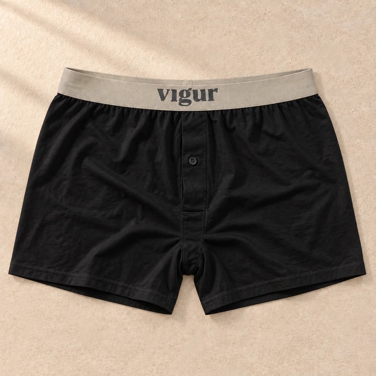 Svarte boxershorts med lys linning merket Vigur, sett forfra på beige bakgrunn