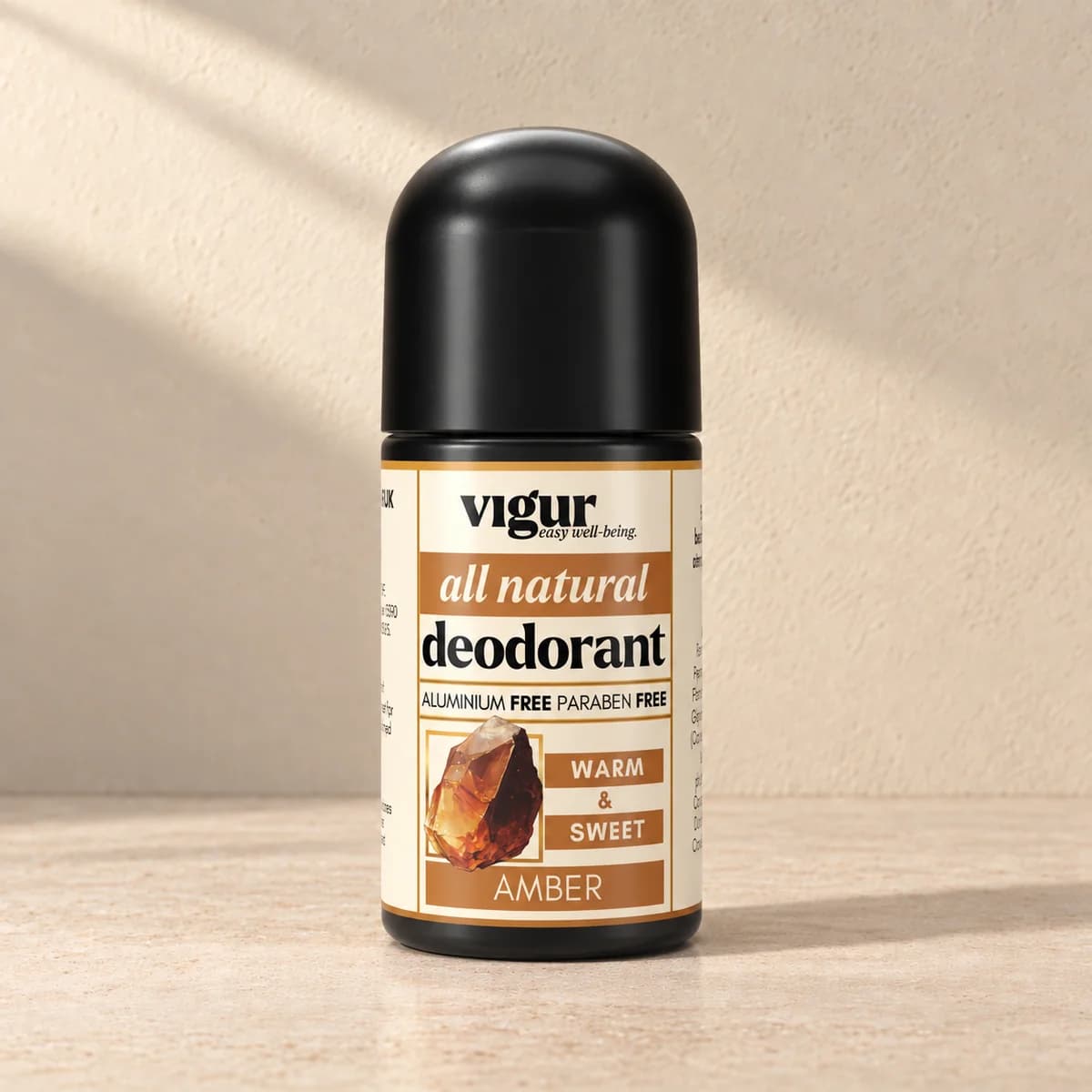 Svart roll-on-deodorant med lys etikett merket Vigur og «Amber» på beige bakgrunn