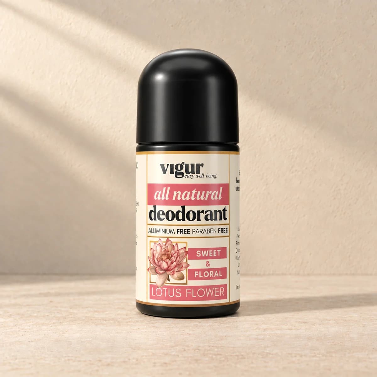 Svart roll-on-deodorant med lys etikett merket Vigur og «Lotus flower» på beige bakgrunn