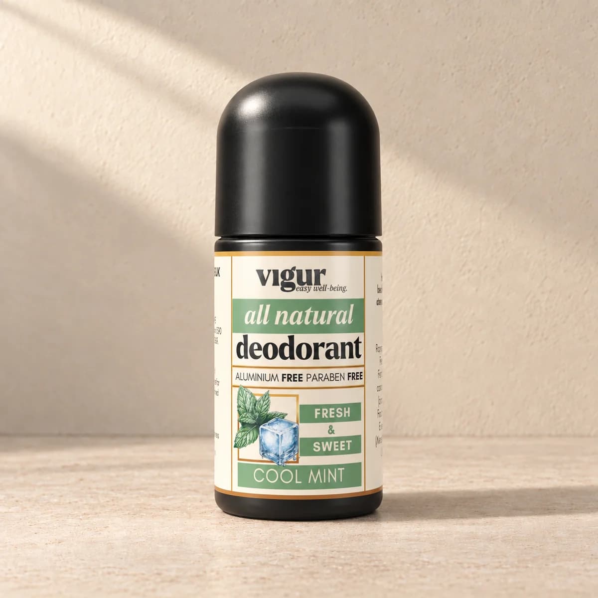 Svart roll-on-deodorant med lys etikett merket Vigur og «Cool Mint» på beige bakgrunn