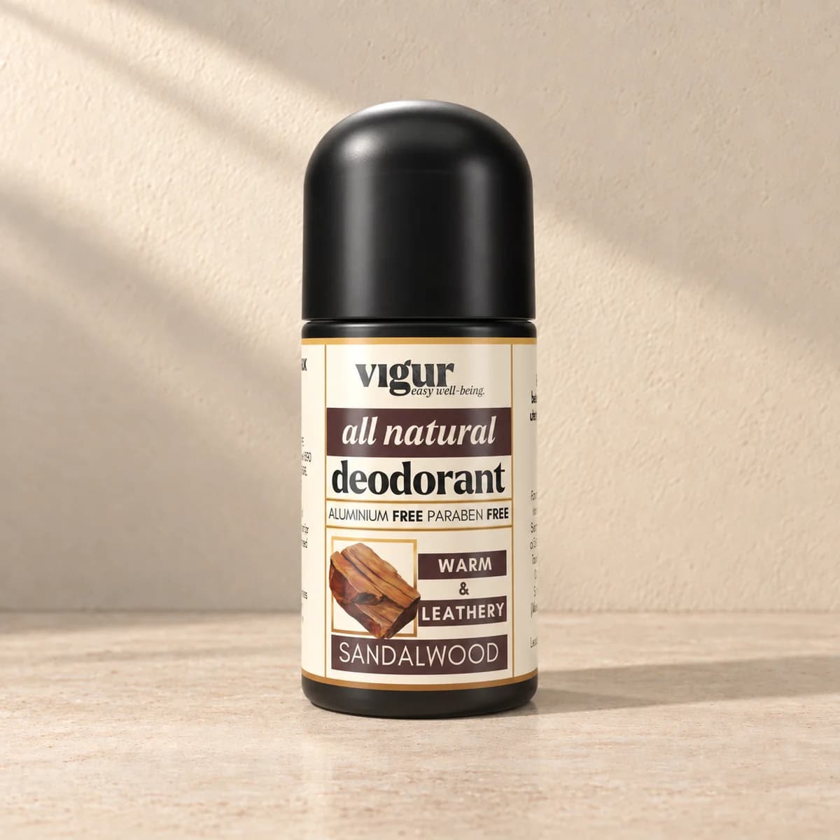 Svart roll-on-deodorant med lys etikett merket Vigur og «Sandalwood» på beige bakgrunn