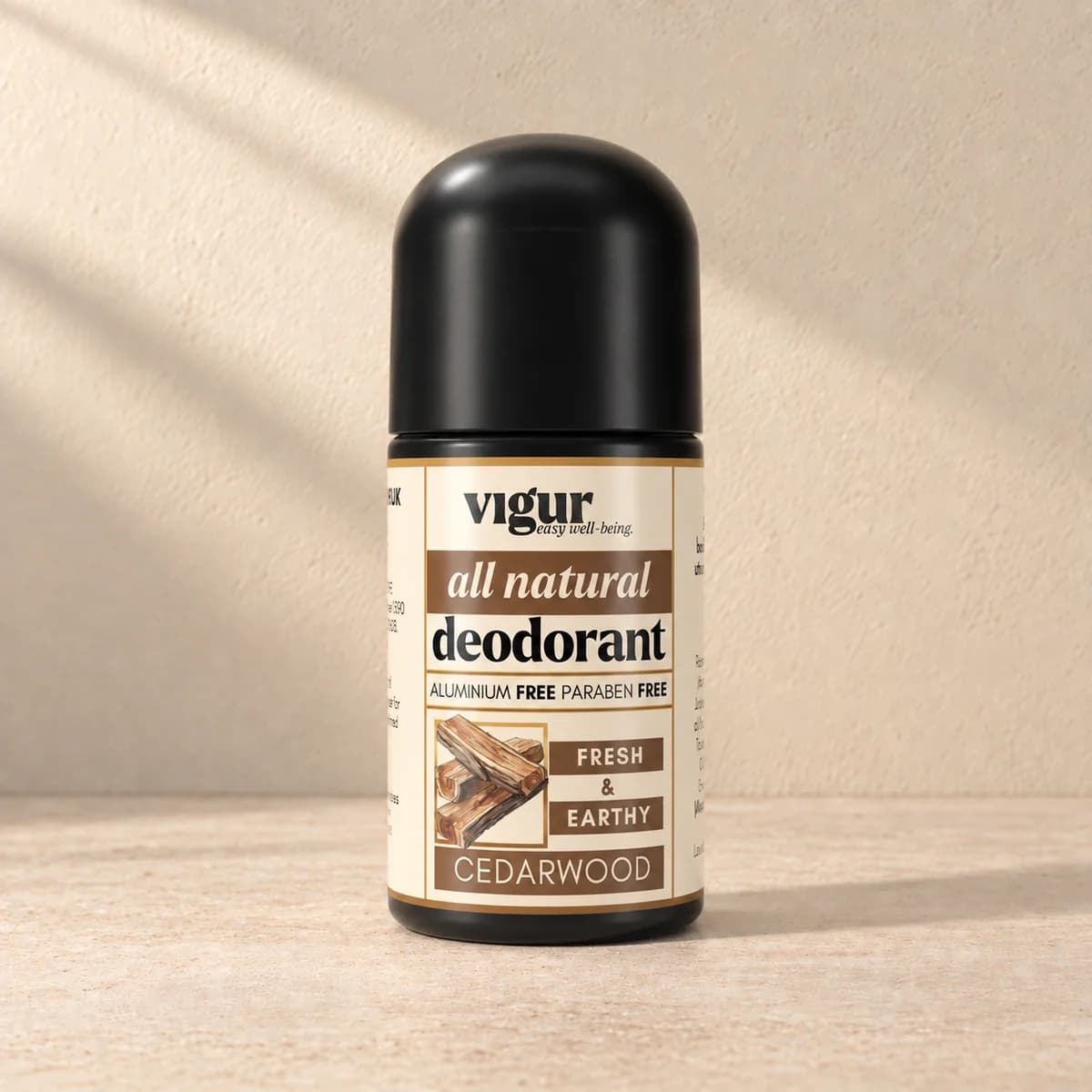 Svart roll-on-deodorant med lys etikett merket Vigur og «Cedarwood» på beige bakgrunn
