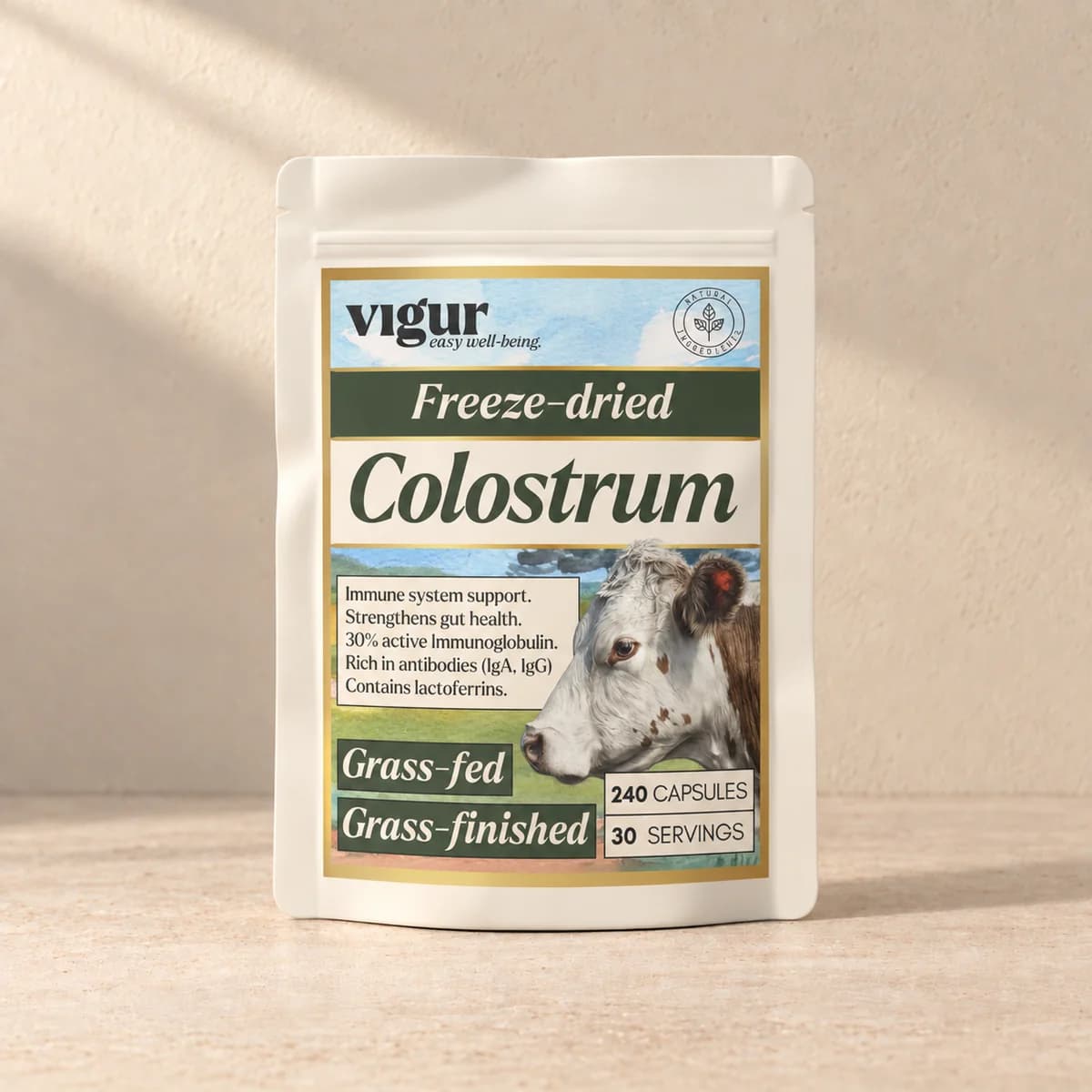 Lys, matt pose med etiketten «Colostrum» og Vigur-logo på beige bakgrunn