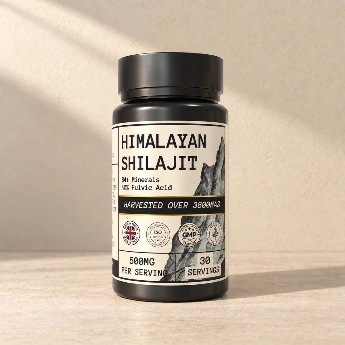 Svart boks med lys etikett «Himalayan Shilajit» og kapselinformasjon på beige bakgrunn