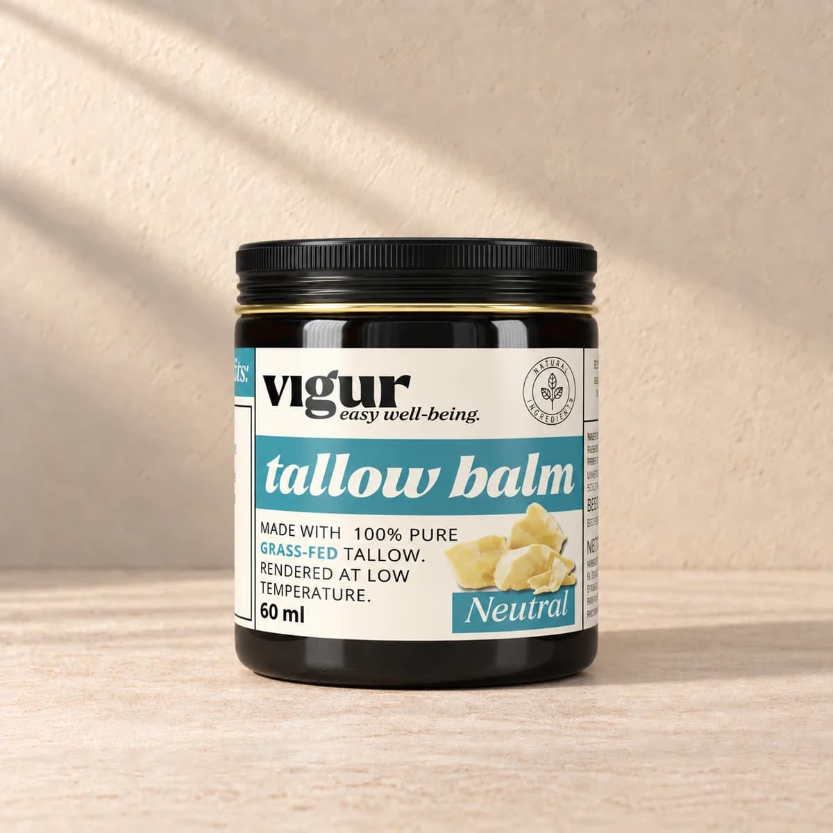 Svart boks med gul og lys etikett merket Vigur og «Tallow balm Neutral» på beige bakgrunn